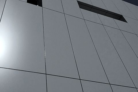 Close view of a flat panel facade with narrow, even joint lines between the panels.